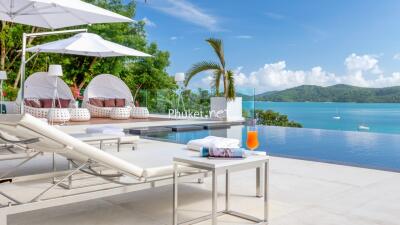 Outdoor lounging area with pool and scenic ocean view