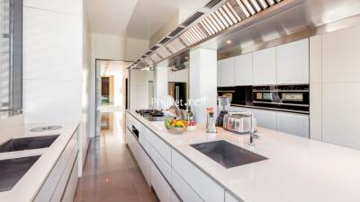 Modern kitchen with white cabinetry, stainless steel appliances, and a spacious island