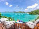 Stunning balcony view of the ocean and surrounding hills with cozy seating.