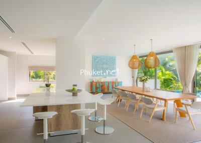 Modern kitchen with adjacent dining area overlooking garden and pool