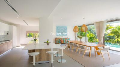 Modern kitchen with adjacent dining area overlooking garden and pool