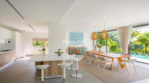 Modern kitchen with adjacent dining area overlooking garden and pool