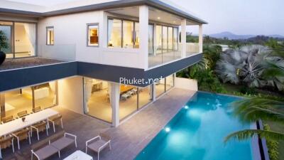 Modern two-story house with large windows and swimming pool