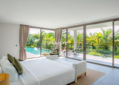 Spacious bedroom with floor-to-ceiling windows and pool view