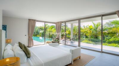 Spacious bedroom with floor-to-ceiling windows and pool view