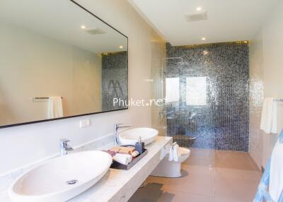 Modern bathroom with double sinks and glass shower