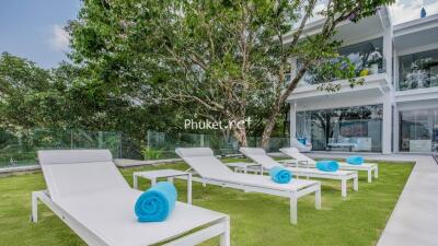 Luxurious outdoor area with sun loungers and modern two-story building