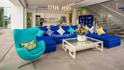 Modern living room with blue sectional sofa and open kitchen