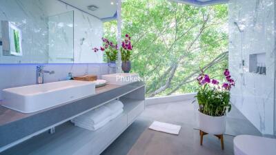 Modern bathroom with a large window view and orchids