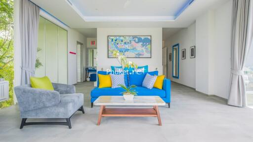 Modern living room with vibrant blue couch and gray armchair