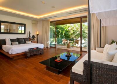 Spacious, modern bedroom with wooden floors and outdoor view