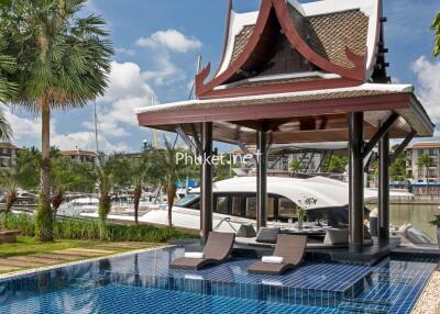 Outdoor seating area by the pool with a view of the marina