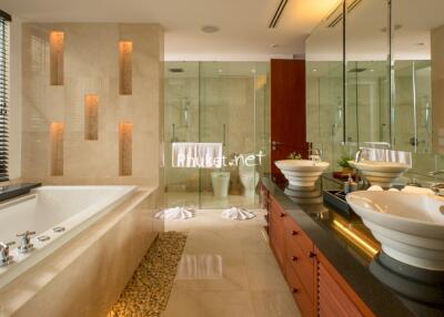 Modern bathroom with dual sinks, bathtub, and large mirrors