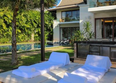 Outdoor lounging area with pool and modern house