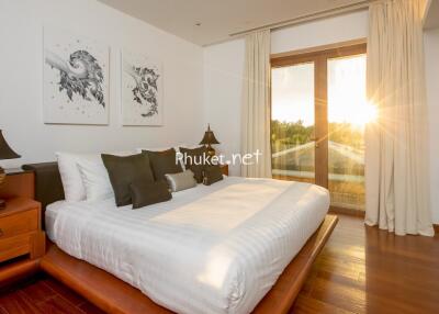 Modern bedroom with artwork and sunset view