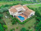 Aerial view of a large house with a pool and garden