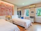 Spacious bedroom with two single beds and decorative tile accent wall