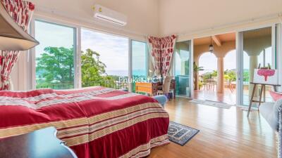 Spacious bedroom with ocean view and balcony access