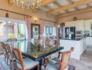 Elegant dining room with a large glass table and kitchen in the background