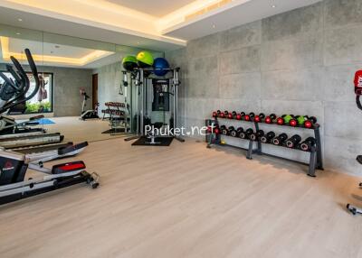 Modern home gym with various fitness equipment and mirrored wall