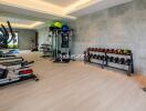 Modern home gym with various fitness equipment and mirrored wall