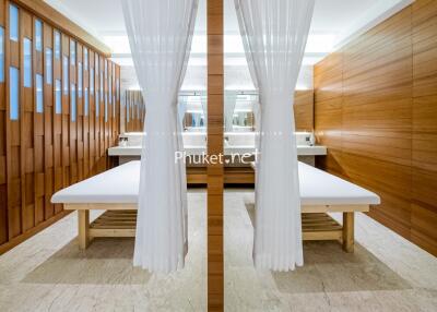 Modern spa treatment room with wooden accents and white curtains