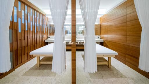 Modern spa treatment room with wooden accents and white curtains