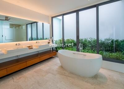 Modern bathroom with large window and freestanding bath