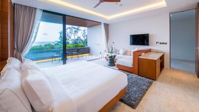 Spacious modern bedroom with balcony and ocean view