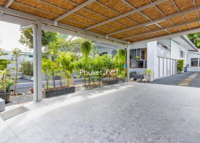 Covered carport with lush greenery in the background