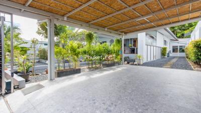 Covered carport with lush greenery in the background