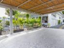 Covered carport with lush greenery in the background