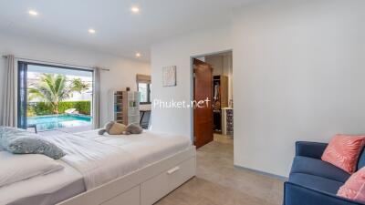 Bedroom with pool view and cozy seating area