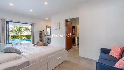 Bedroom with pool view and cozy seating area