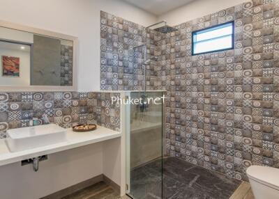 Modern bathroom with patterned tiles and a walk-in shower
