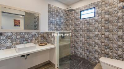 Modern bathroom with patterned tiles and a walk-in shower