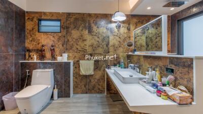 Modern bathroom with decorative wall tiles, sink and amenities