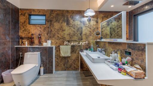 Modern bathroom with decorative wall tiles, sink and amenities