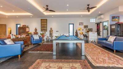 Spacious and modern living room with pool table and decorative accents