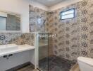 Modern bathroom with patterned tiles, glass-enclosed shower, and sleek fixtures