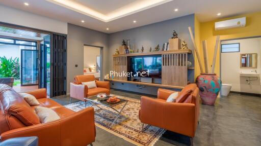 Modern living room with orange leather sofas, wall-mounted TV and decorative shelving