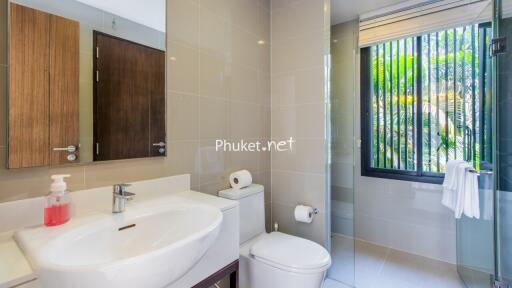 Modern bathroom with sink, toilet, and shower with glass door