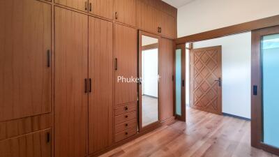 Spacious bedroom with wooden storage cabinets and mirror