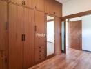 Spacious bedroom with wooden storage cabinets and mirror