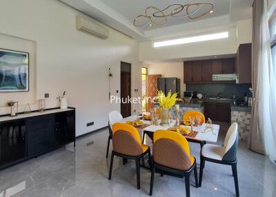 Modern dining and kitchen area with yellow chairs and contemporary lighting