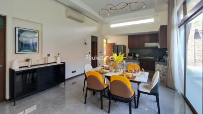 Modern dining and kitchen area with yellow chairs and contemporary lighting