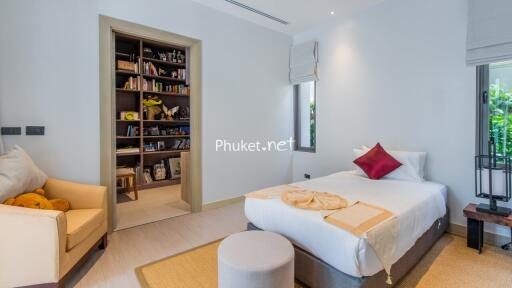 Cozy bedroom with a bookshelf, bed, and sitting area