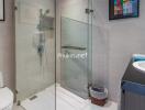 Modern bathroom with glass shower enclosure, white toilet, and wall-mounted sink