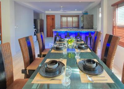 Modern dining area with a glass table and black tableware