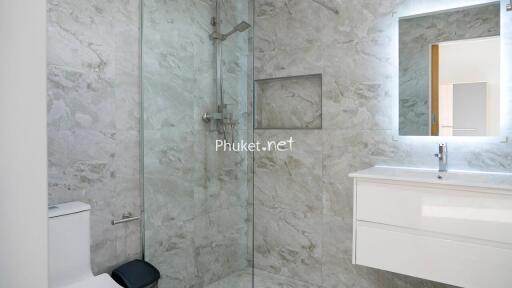 Modern bathroom with glass shower and marble walls